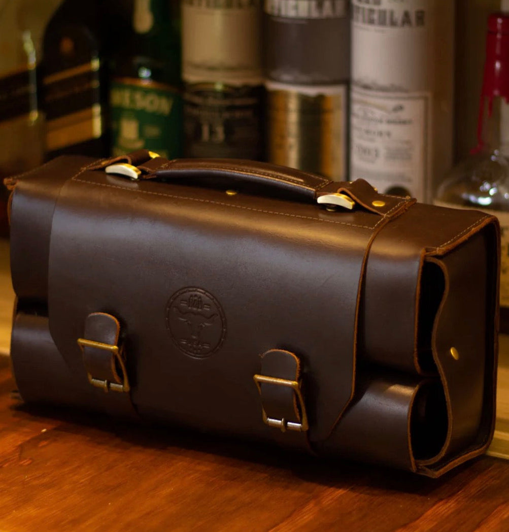 Brown leather briefcase on a wooden surface with bottles in the background